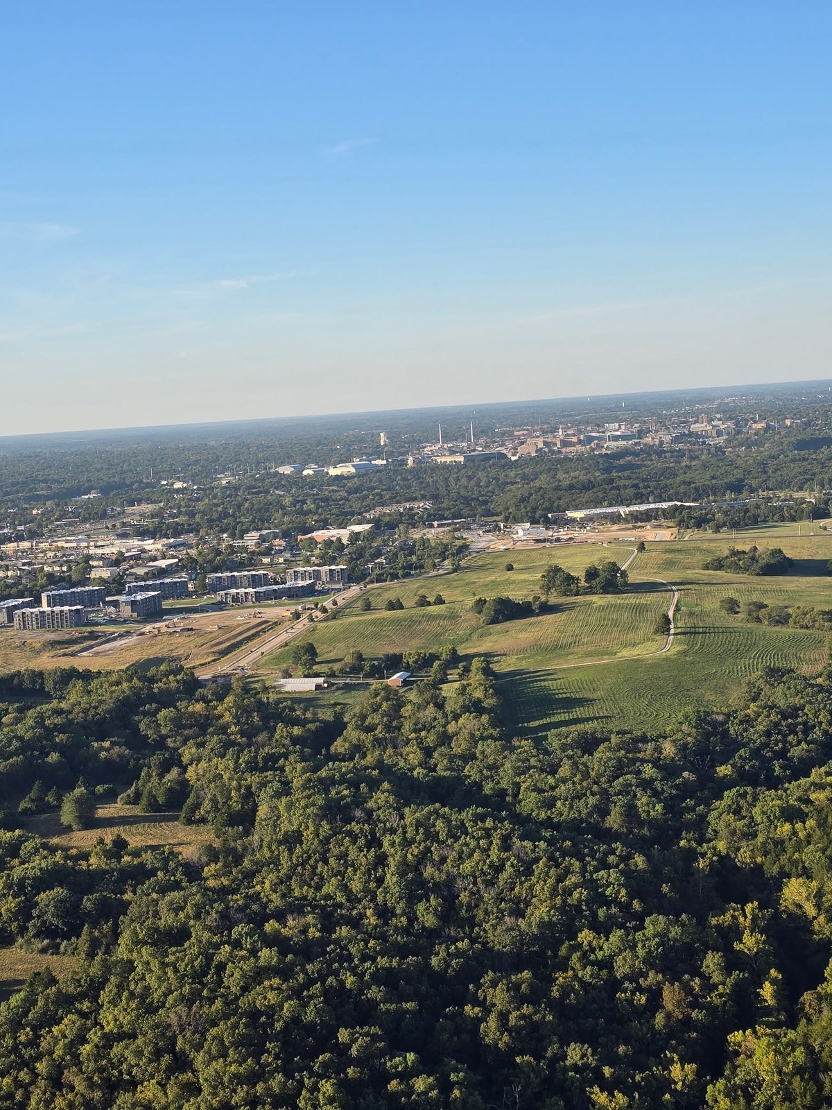 Aerial view of fields, forest and the Columbia, Missouri skyline from a hot air balloon