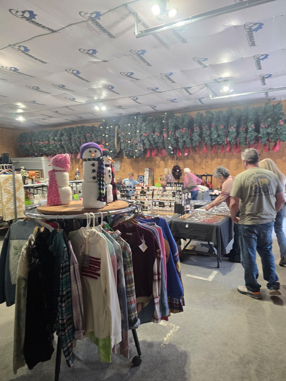 Craft vendors, snowmen decor and handmade clothing inside a barn at Heritage Days