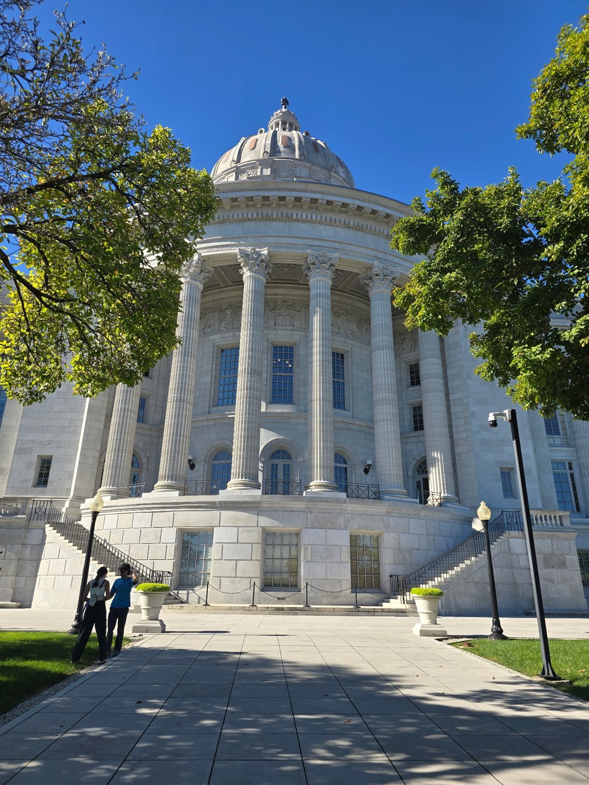 Columns and dome of the Missouri State Capitol framed by trees