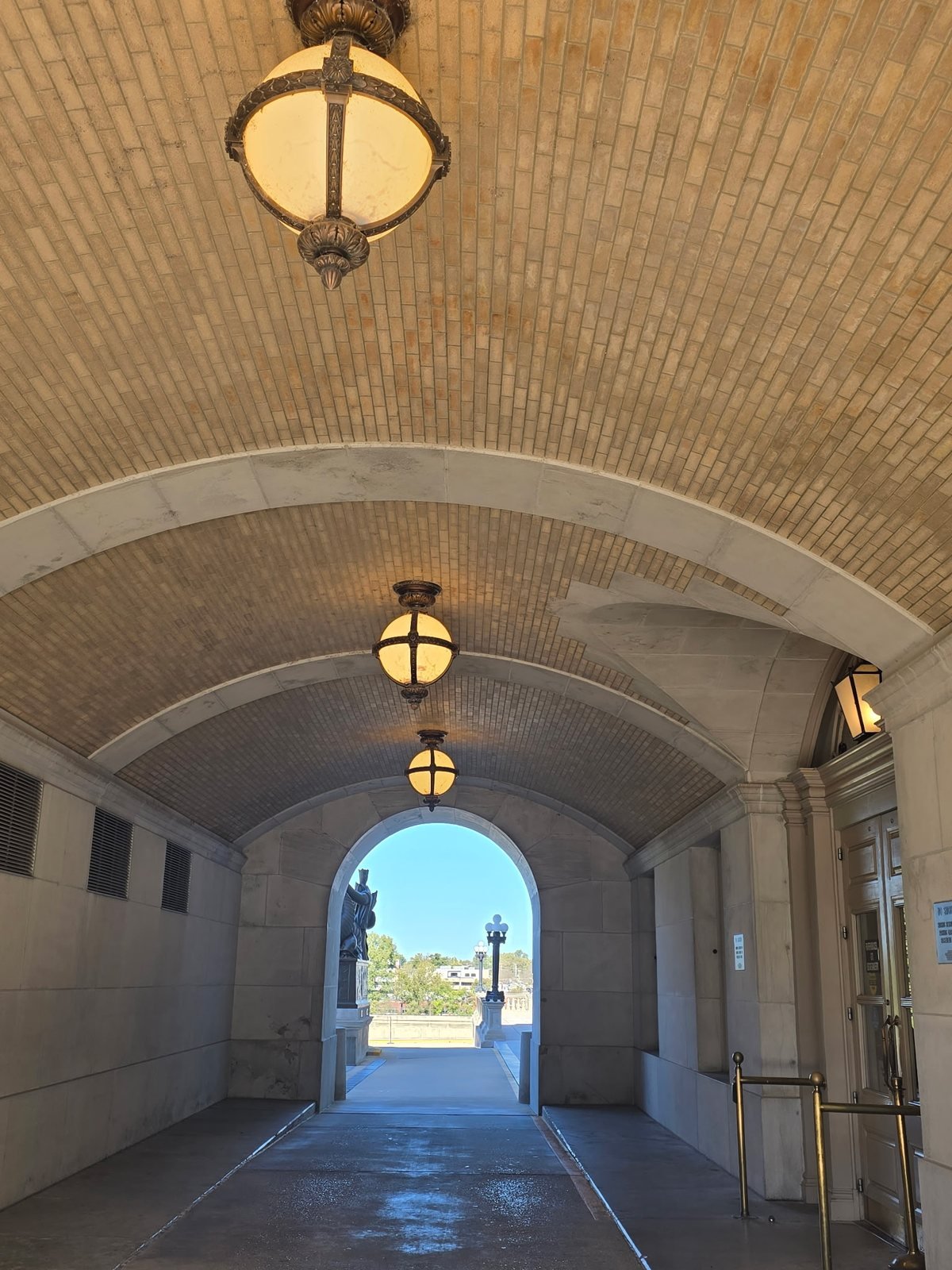 Arched carriage entrance with hanging lanterns at the Missouri State Capitol
