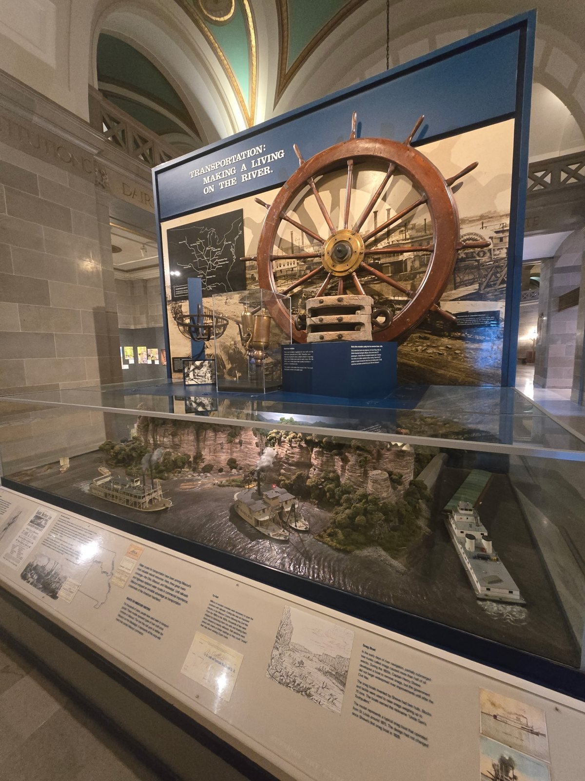 River history exhibit with a ship's wheel at the Missouri State Museum