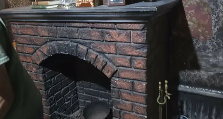 Old brick fireplace with glass-domed clock and vintage photos on the mantel in the Burn escape room